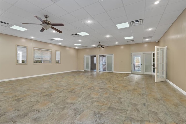 unfurnished room with ceiling fan, a drop ceiling, and french doors