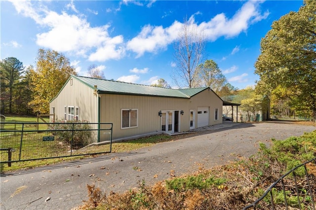 view of side of property featuring french doors and a garage