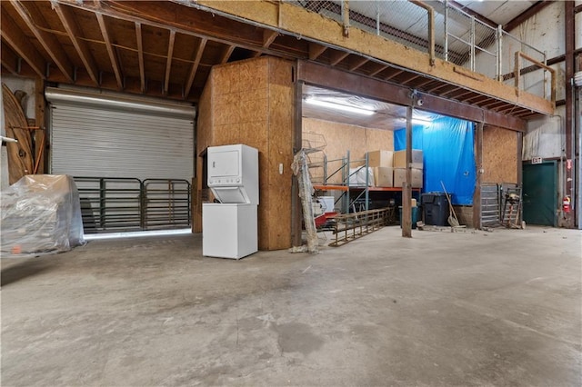 garage with stacked washing maching and dryer