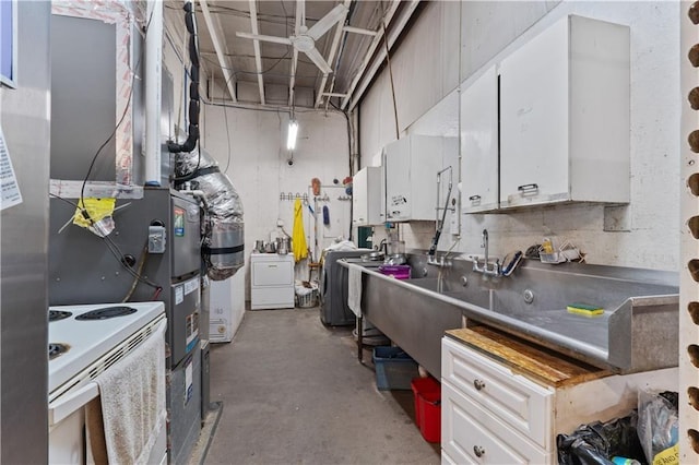 kitchen with white range with electric stovetop, white cabinetry, and washer / clothes dryer