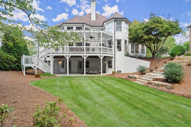 back of property with a wooden deck, a yard, and a patio