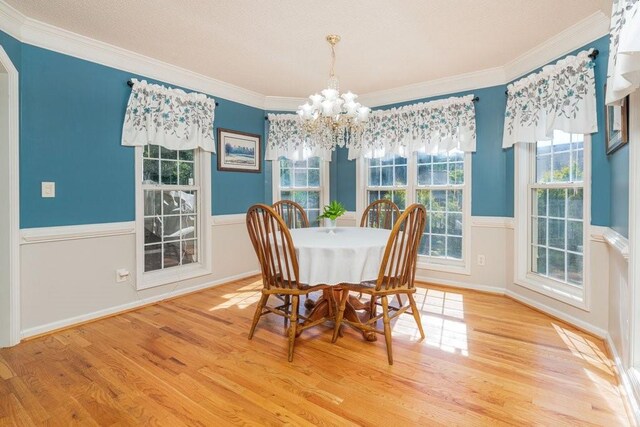 dining space featuring a chandelier, light hardwood / wood-style floors, and ornamental molding