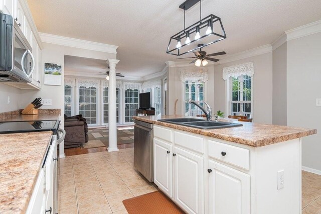 kitchen featuring white cabinetry, sink, a center island with sink, appliances with stainless steel finishes, and ornamental molding