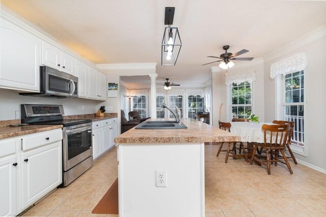 kitchen with appliances with stainless steel finishes, a center island with sink, a wealth of natural light, and sink