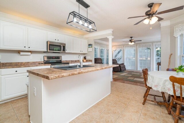 kitchen featuring white cabinets, sink, stainless steel appliances, and an island with sink