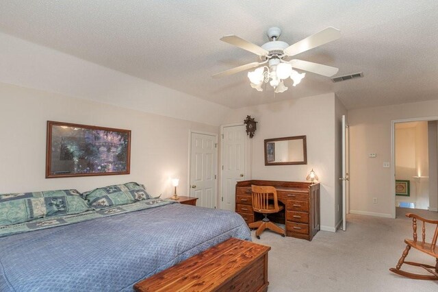 carpeted bedroom featuring a textured ceiling, vaulted ceiling, and ceiling fan