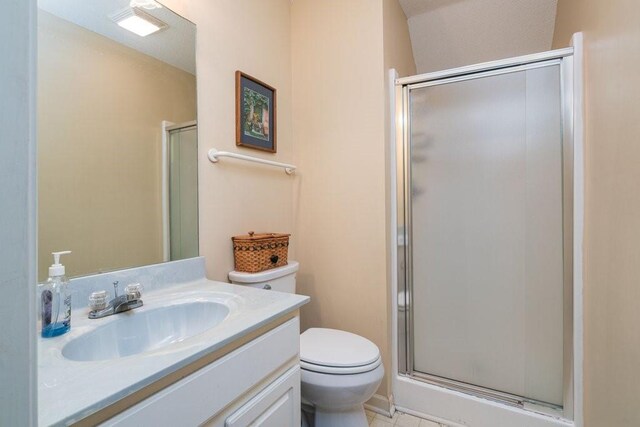 bathroom featuring walk in shower, tile patterned flooring, vanity, and toilet