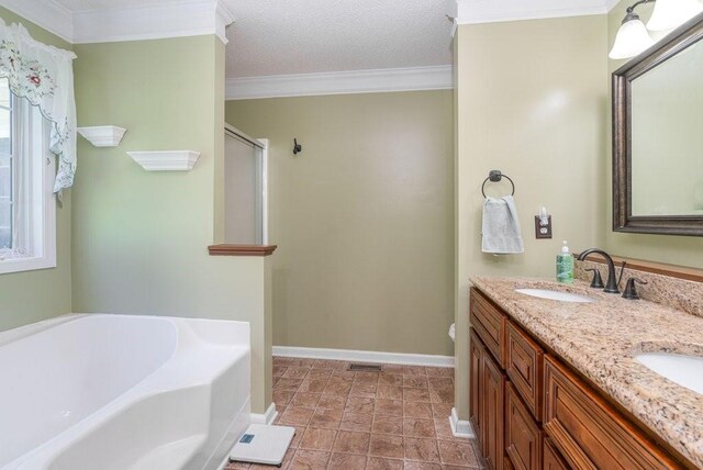 bathroom featuring a textured ceiling, vanity, a wealth of natural light, and ornamental molding