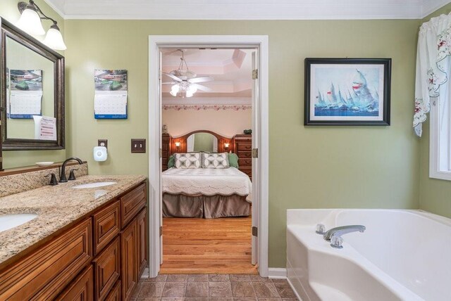 bathroom featuring a bathing tub, ceiling fan, crown molding, wood-type flooring, and vanity