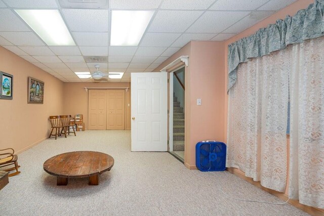 sitting room featuring carpet floors and a drop ceiling