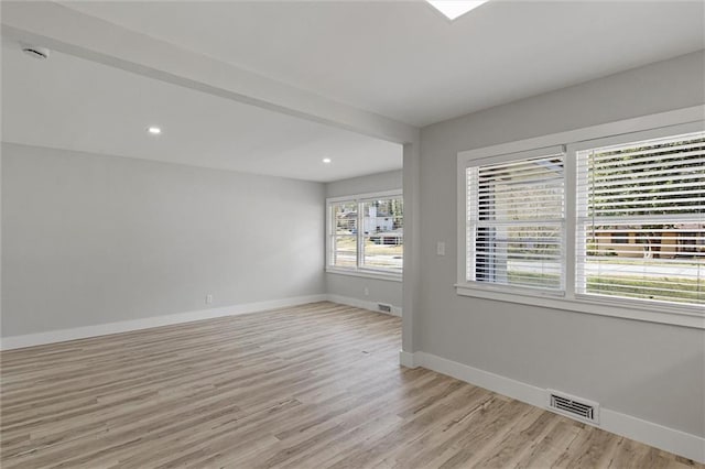 empty room featuring light wood-style flooring, recessed lighting, baseboards, and visible vents