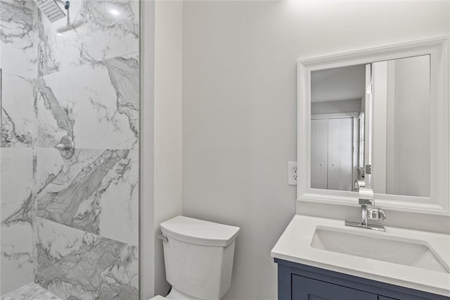 bathroom featuring a marble finish shower, toilet, and vanity