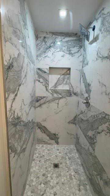 full bathroom featuring a marble finish shower