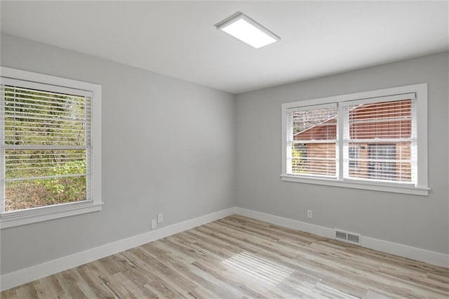 empty room with plenty of natural light, visible vents, and baseboards