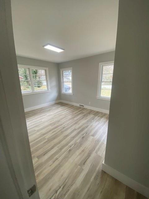 empty room featuring light wood-type flooring and baseboards