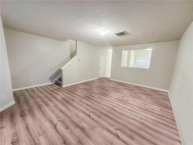 interior space featuring a textured ceiling and light wood-type flooring