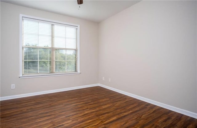 empty room with ceiling fan and dark hardwood / wood-style flooring