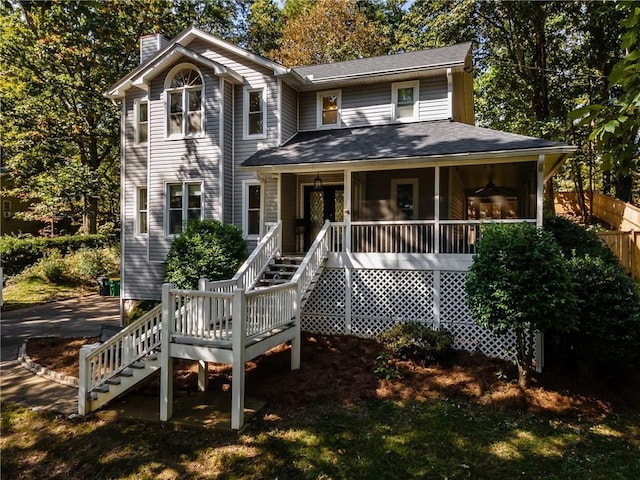 view of front facade with fence, a chimney, and stairs