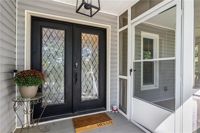 entrance to property with a porch and french doors