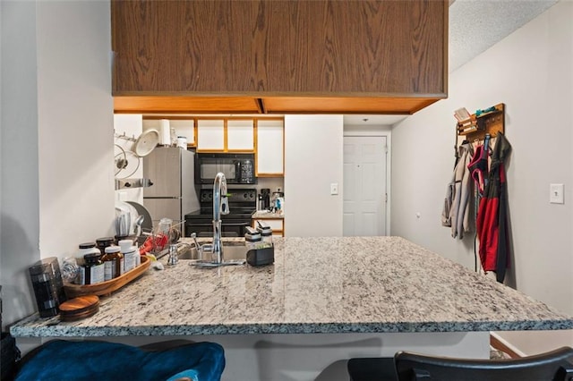 795 Hammond Dr Unit 505, Atlanta, GA 30328 - kitchen with black microwave, freestanding refrigerator, a kitchen bar, and electric range oven