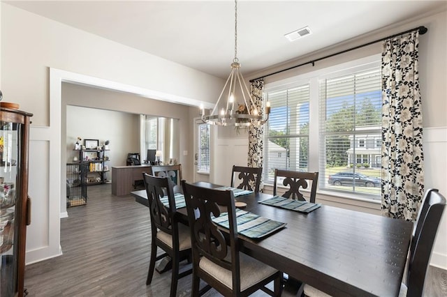 dining area with dark hardwood / wood-style flooring, plenty of natural light, and a notable chandelier