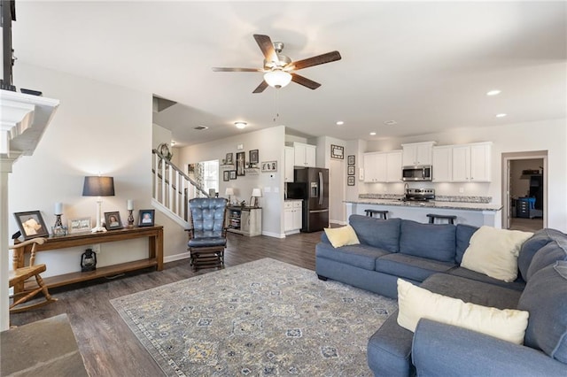 living room featuring ceiling fan and dark hardwood / wood-style flooring