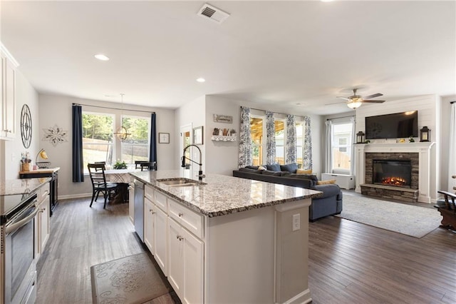 kitchen featuring sink, dark hardwood / wood-style flooring, a center island with sink, white cabinets, and appliances with stainless steel finishes