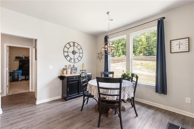 dining space with dark hardwood / wood-style flooring and a notable chandelier