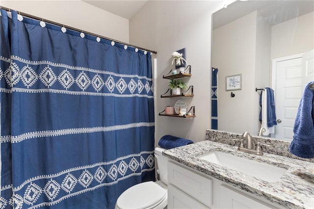 bathroom with curtained shower, vanity, and toilet