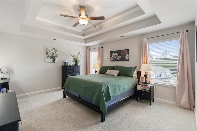 bedroom featuring ceiling fan, carpet floors, crown molding, and a tray ceiling