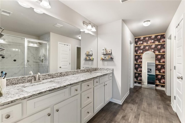 bathroom with wood-type flooring, vanity, and walk in shower