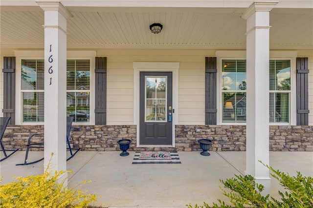 view of exterior entry featuring covered porch