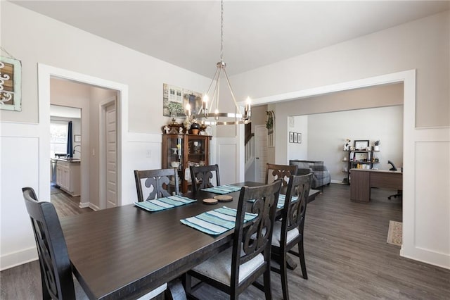 dining room with dark hardwood / wood-style flooring and an inviting chandelier