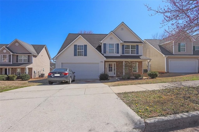 traditional home featuring an attached garage, concrete driveway, and brick siding