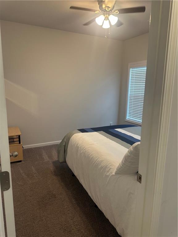 495 Sterling Creek Way, Loganville, GA 30052 - living area featuring wood finished floors, coffered ceiling, ceiling fan, beam ceiling, and stairway