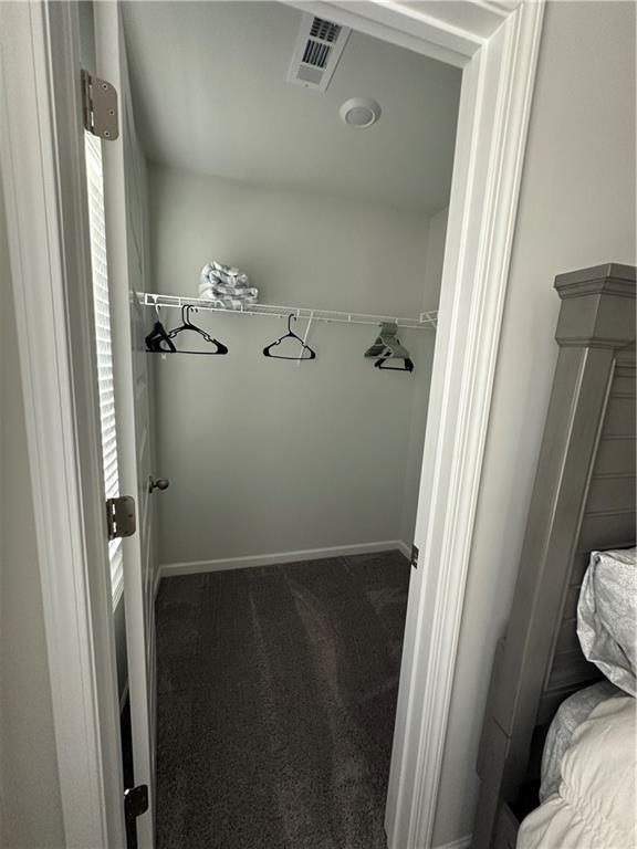 495 Sterling Creek Way, Loganville, GA 30052 - bedroom with dark carpet and a ceiling fan