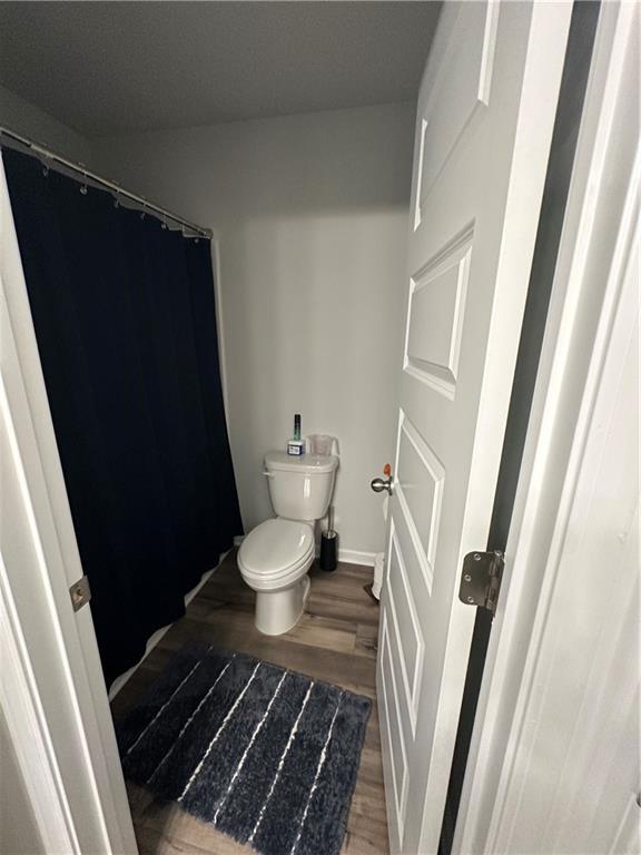 495 Sterling Creek Way, Loganville, GA 30052 - full bath with wood finished floors, vanity, and curtained shower