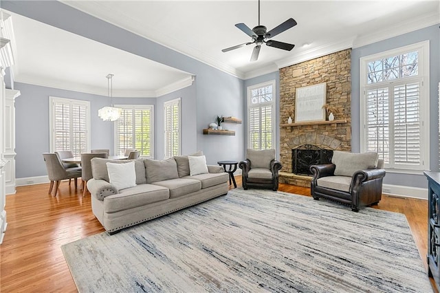 4080 Glen Hill Way NE, Marietta, GA 30066 - living room with crown molding, light wood-style flooring, baseboards, a stone fireplace, and a ceiling fan