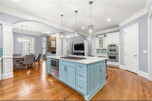 4080 Glen Hill Way NE, Marietta, GA 30066 - kitchen with ornate columns, blue cabinets, stainless steel appliances, a warming drawer, and white cabinets