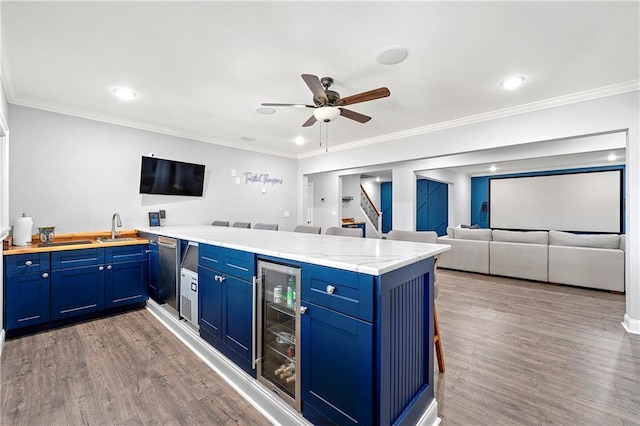 4080 Glen Hill Way NE, Marietta, GA 30066 - kitchen featuring wine cooler, a peninsula, blue cabinetry, wood finished floors, and ornamental molding