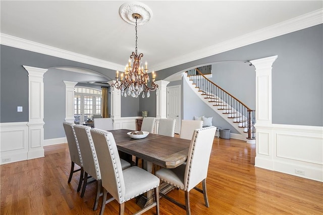 4080 Glen Hill Way NE, Marietta, GA 30066 - dining space with arched walkways, decorative columns, wood finished floors, a chandelier, and crown molding