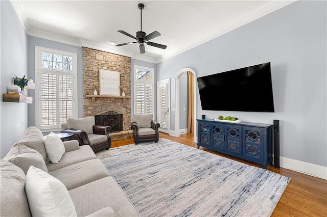 4080 Glen Hill Way NE, Marietta, GA 30066 - living room featuring crown molding, baseboards, wood finished floors, a ceiling fan, and a stone fireplace