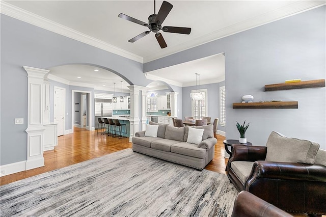 4080 Glen Hill Way NE, Marietta, GA 30066 - living room featuring ornate columns, arched walkways, light wood-style flooring, plenty of natural light, and crown molding