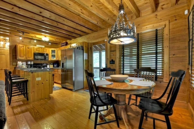 dining space with wooden ceiling, beam ceiling, wood walls, and light wood-style flooring