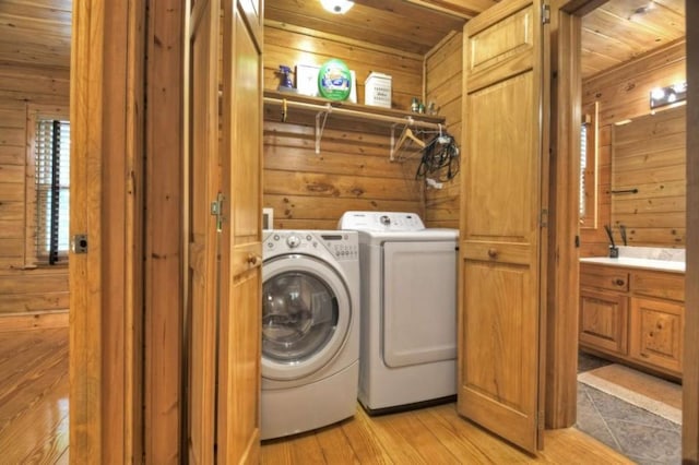 laundry area with washing machine and clothes dryer, wood walls, laundry area, and wood ceiling