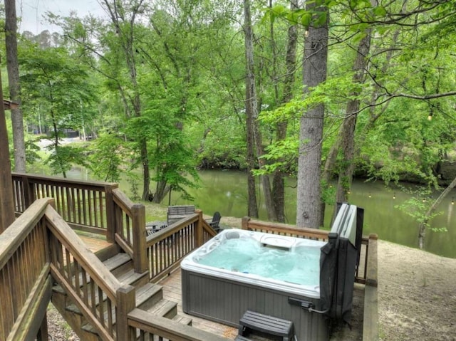 wooden deck featuring a water view and a hot tub