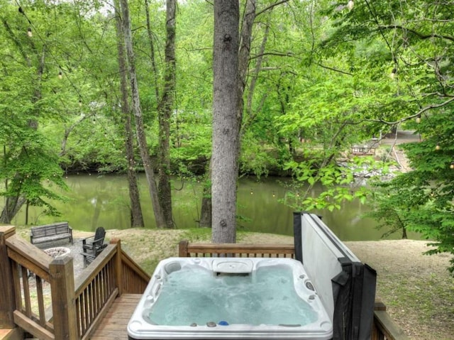 wooden deck with a hot tub and a water view
