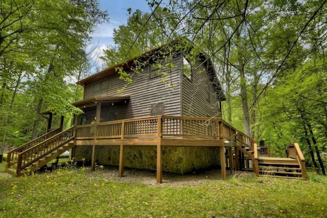 rear view of property featuring stairway and a deck
