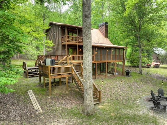 view of playground with a sunroom, stairway, and a deck
