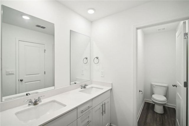 bathroom with vanity, toilet, and hardwood / wood-style floors